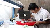 Guy using an industrial sander on a piece of sheet metal