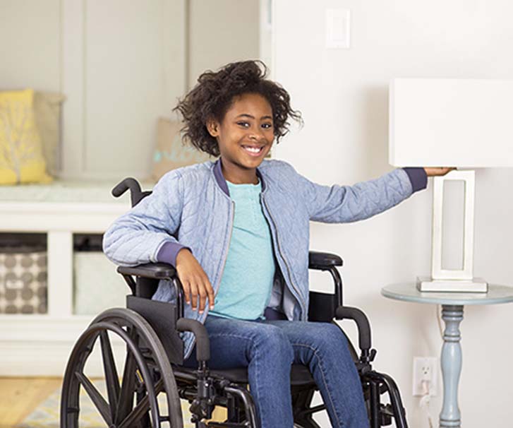 girl in wheelchair turning on lamp